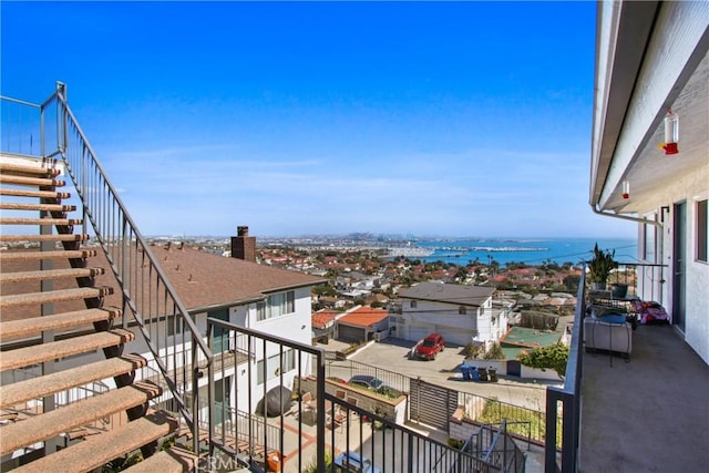 balcony featuring a water view and stairway