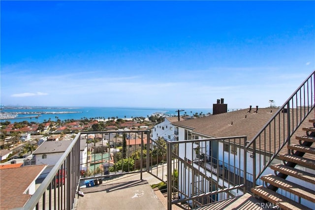 balcony featuring stairway and a water view