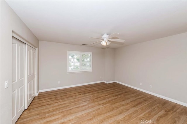 unfurnished bedroom with visible vents, a closet, light wood-style flooring, and baseboards