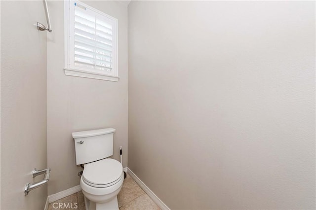 bathroom featuring toilet, baseboards, and tile patterned floors