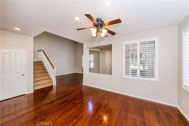 empty room featuring recessed lighting, wood-type flooring, stairway, and baseboards