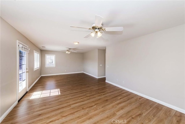 spare room featuring a ceiling fan, baseboards, and wood finished floors