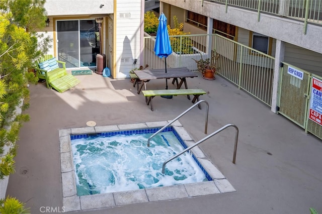 view of swimming pool with a community hot tub and a patio area