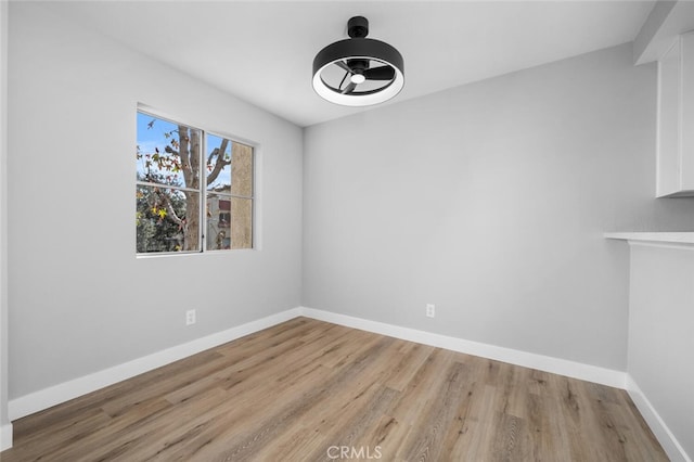 unfurnished dining area with a ceiling fan, baseboards, and wood finished floors