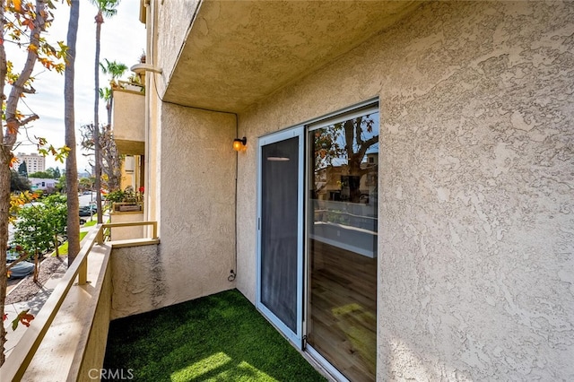 entrance to property with a balcony and stucco siding