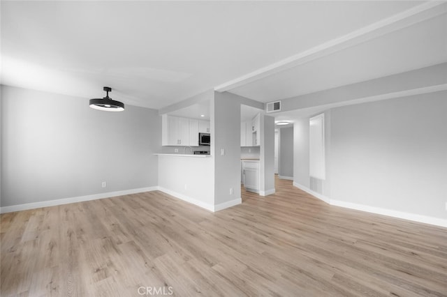 unfurnished living room featuring light wood-style flooring, visible vents, and baseboards