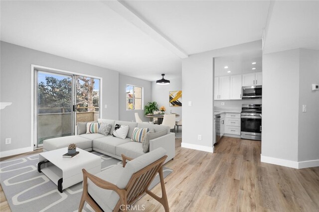 living room featuring baseboards, recessed lighting, and light wood-style floors