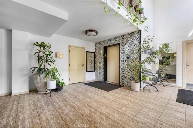 interior space featuring wallpapered walls and baseboards