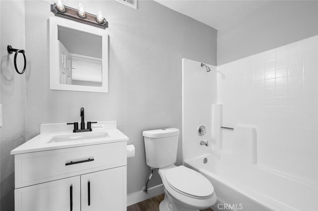 bathroom featuring baseboards, toilet,  shower combination, vanity, and wood finished floors