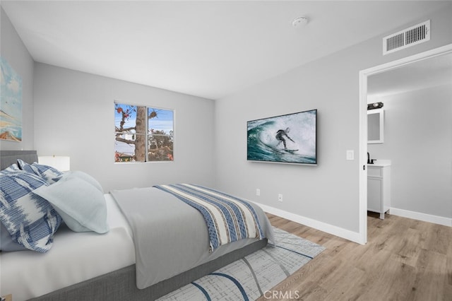 bedroom with light wood finished floors, baseboards, and visible vents