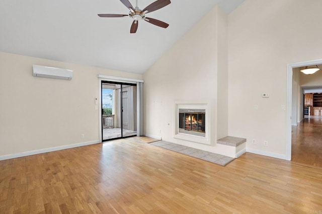 unfurnished living room featuring high vaulted ceiling, a fireplace, baseboards, light wood-style floors, and a wall mounted AC