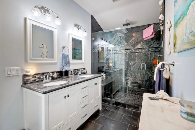 full bath with double vanity, a stall shower, and a sink