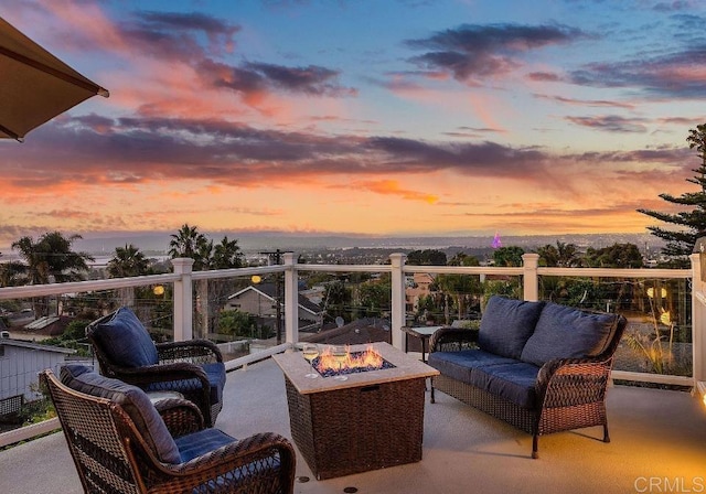 patio terrace at dusk with an outdoor living space with a fire pit