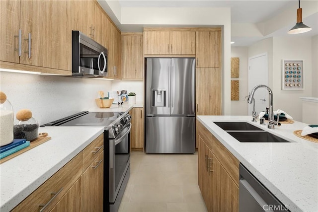 kitchen featuring light tile patterned floors, appliances with stainless steel finishes, light stone counters, hanging light fixtures, and a sink