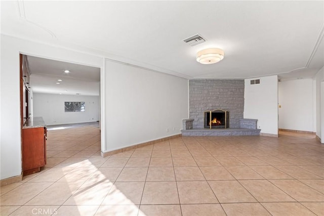 unfurnished living room featuring light tile patterned floors, a fireplace, visible vents, and baseboards