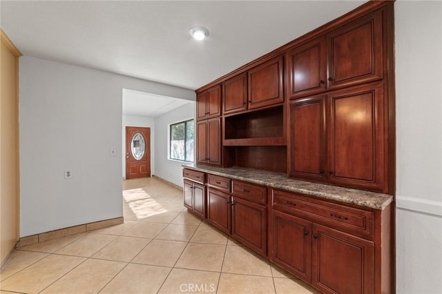 kitchen featuring open shelves, light tile patterned flooring, and baseboards