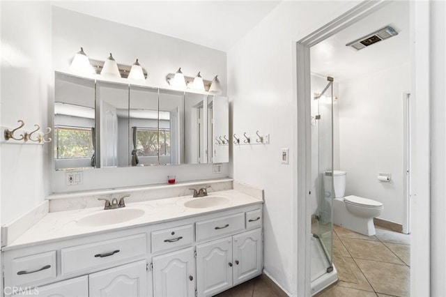 bathroom with a shower stall, double vanity, visible vents, and a sink