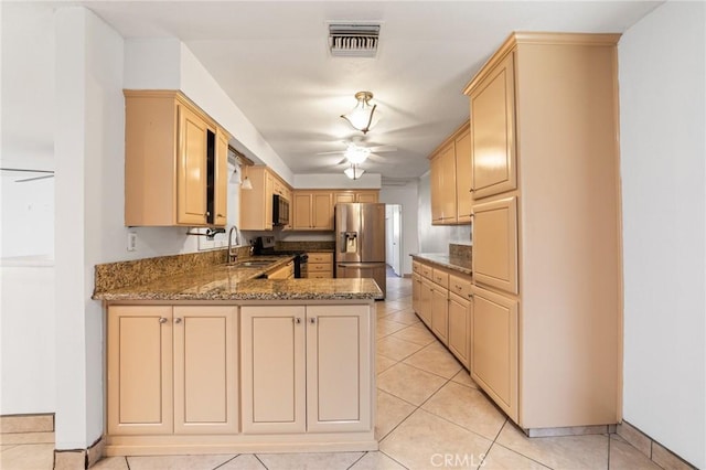 kitchen with visible vents, black microwave, stainless steel fridge with ice dispenser, a peninsula, and stove