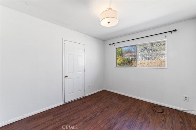 empty room with wood finished floors and baseboards