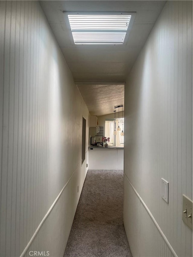 hall featuring carpet flooring and vaulted ceiling