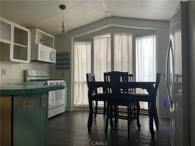 dining room with vaulted ceiling and dark wood-type flooring