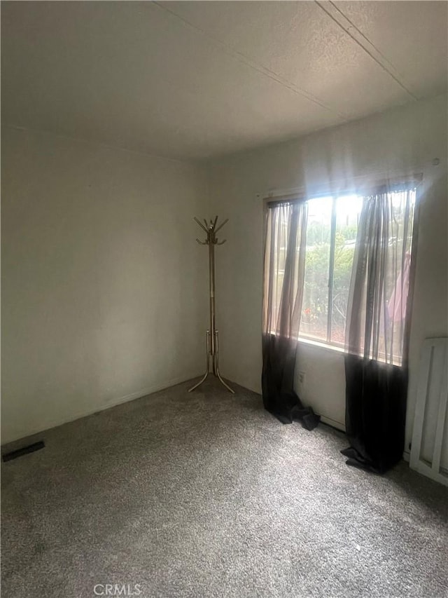 empty room with radiator heating unit and visible vents