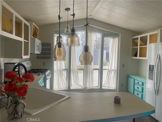 kitchen featuring white appliances, light countertops, lofted ceiling, and open shelves