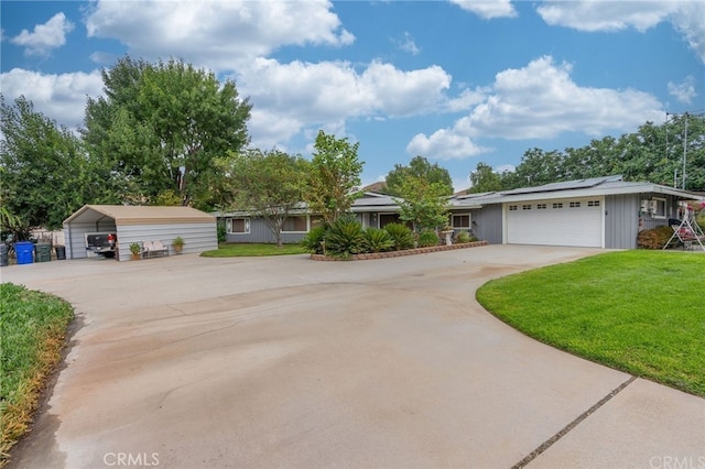 ranch-style house with solar panels, an attached garage, a front yard, a carport, and driveway