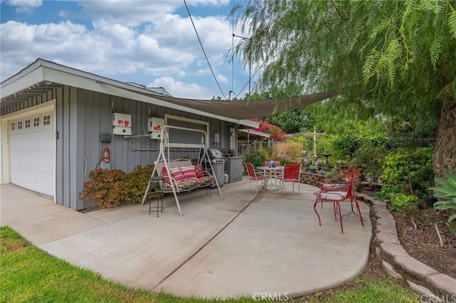 view of patio / terrace featuring fence and a garage