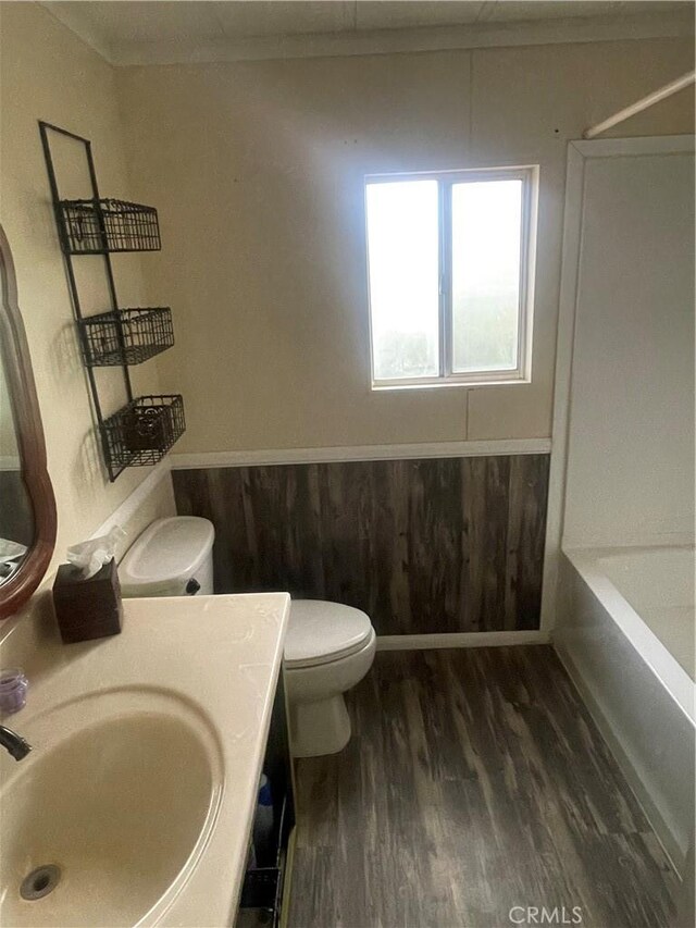 bathroom with toilet, wood finished floors, and vanity