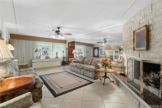 living room with a ceiling fan, light tile patterned floors, a fireplace, and visible vents