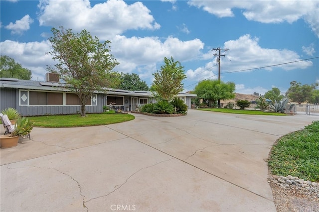 single story home featuring roof mounted solar panels and a front yard