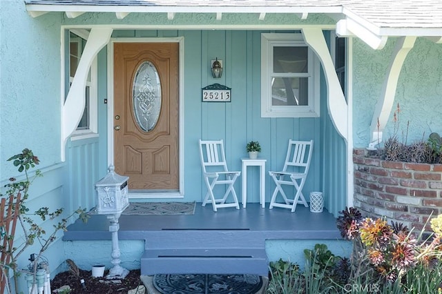 property entrance featuring covered porch and stucco siding