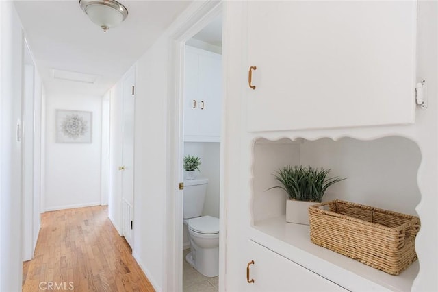 hall featuring attic access and light wood-style floors