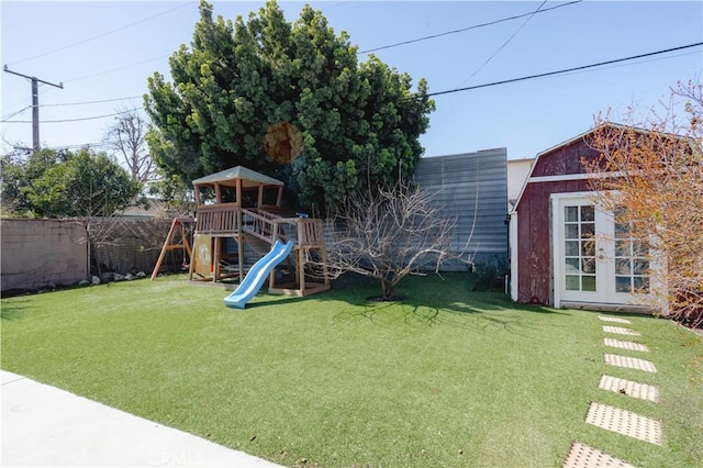 view of yard with french doors, a playground, and fence