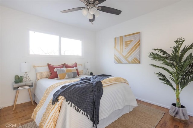 bedroom featuring wood finished floors, a ceiling fan, and baseboards