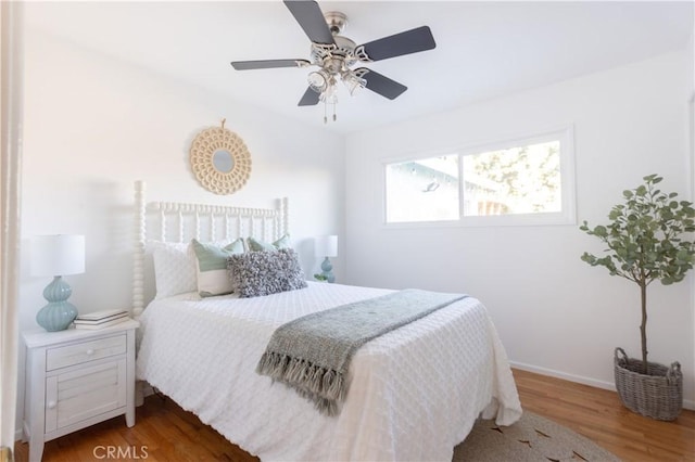 bedroom featuring ceiling fan, wood finished floors, and baseboards