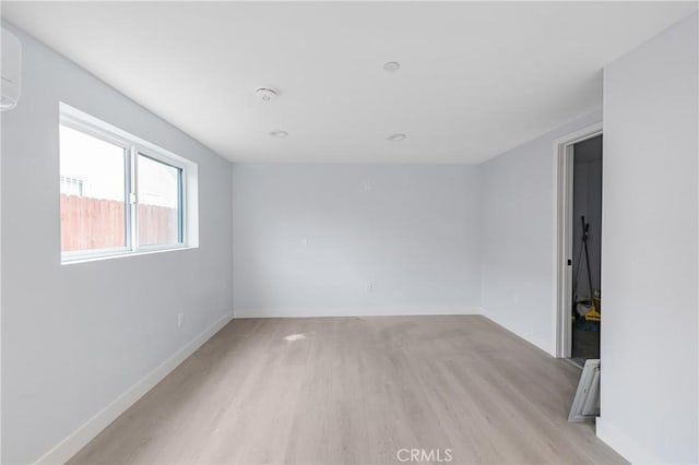 spare room with light wood-type flooring and baseboards