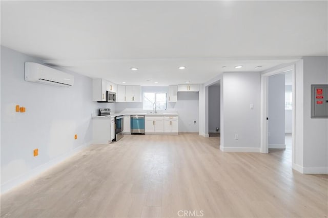 unfurnished living room with light wood finished floors, a wall mounted AC, electric panel, and baseboards