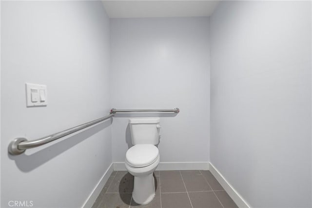 bathroom with baseboards, toilet, and tile patterned floors