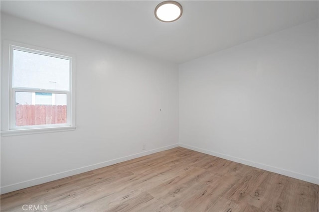 empty room featuring light wood-style flooring and baseboards