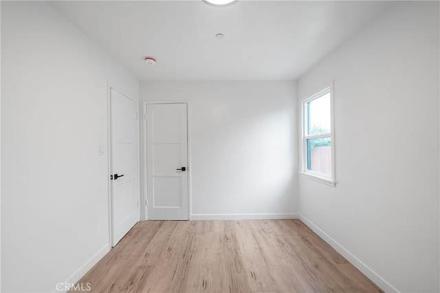 empty room featuring light wood-style floors and baseboards