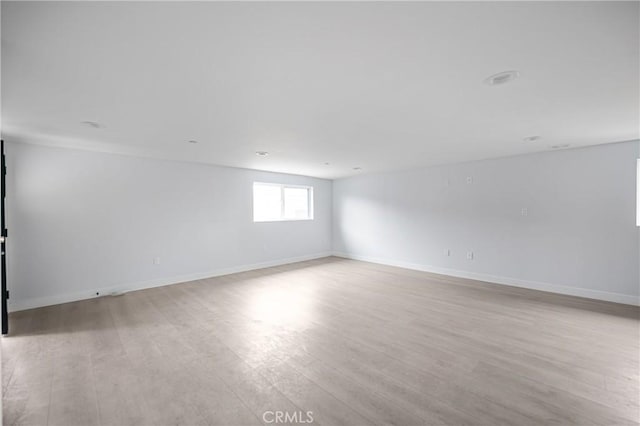 unfurnished room with baseboards and light wood finished floors