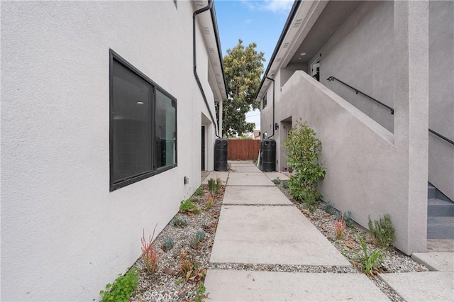 view of home's exterior featuring cooling unit, fence, and stucco siding