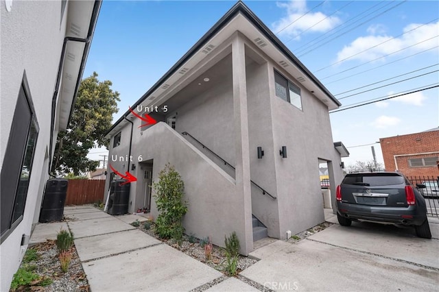 view of side of home featuring fence and stucco siding