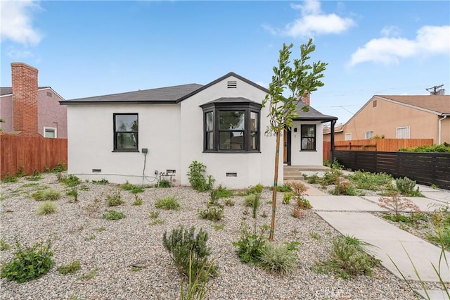 bungalow with crawl space, fence, and stucco siding