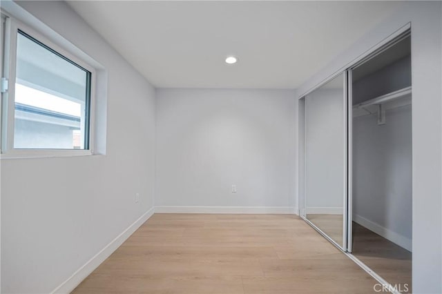 unfurnished bedroom with light wood-style floors, recessed lighting, a closet, and baseboards