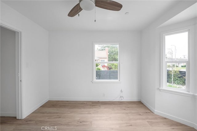 empty room featuring light wood-style floors, ceiling fan, and baseboards