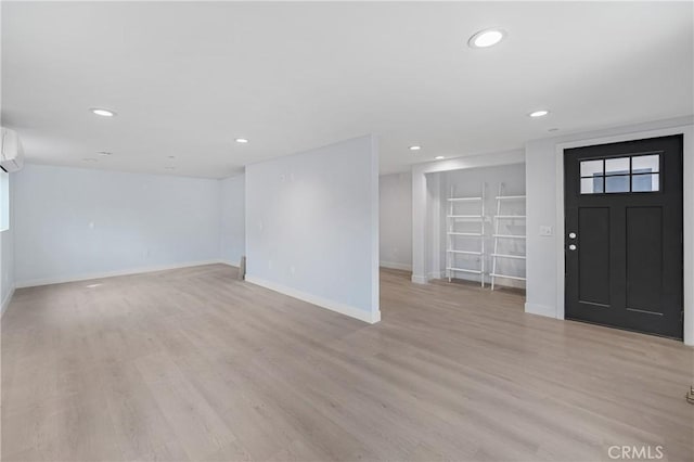 foyer featuring recessed lighting, a wall unit AC, light wood-style flooring, and baseboards