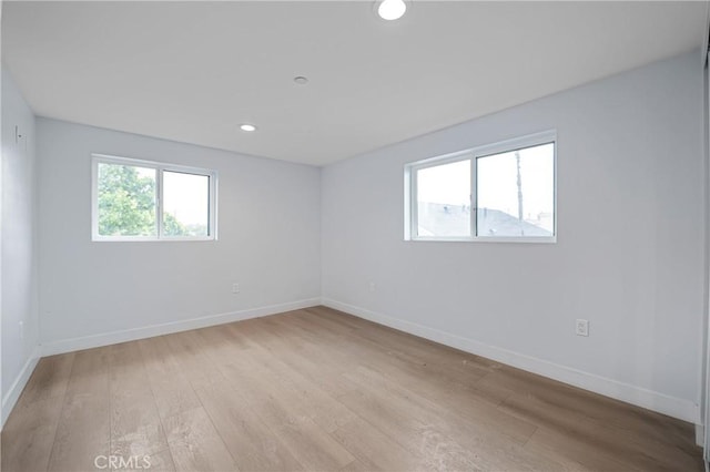 empty room featuring recessed lighting, light wood-style flooring, and baseboards